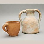 Fig. 17 Cup and bottle attributed to William F. James; Farmington, Davie County, NC; ca. 1870-1939. Unglazed earthenware; HOA 3 1/2˝ (cup); HOA 6 3/4˝ (bottle). Author’s collection. Photograph by the author. James’ ware is often thick-walled, with handles distinctively attached to the vessels’ rims. The bottle bears paint residue.