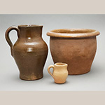 Fig. 18 Large pitcher, small pitcher, and crock attributed to William F. James; Farmington, Davie County, NC; ca. 1870-1939. Lead-glazed and bisque-fired earthenware; HOA 9˝ (lg. pitcher); HOA 3˝ (sm. Pitcher); HOA 7 1/2˝ (crock). Author’s collection. Photograph by the author. The small unglazed pitcher holds a note indicating that it was purchased at the James Pottery, Farmington, N.C.