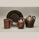 Fig. 50 Tankard, dish, and jugs by an unknown maker; Piedmont Region, NC; ca. nineteenth century. Lead-glazed earthenware. HOA 5 3/8˝ (tankard); DOA 10 3/4˝ (dish); HOA 6 1/4˝ (small jug); HOA 7 1/2˝ (large jug). Author’s collection. Jug on the right, private collection. Photograph by the author. Objects like these, with rusty-looking lead glaze finishes, collected from Yadkin, Davie, and nearby counties, share traits (clay, glaze, form, etc.) with Yadkin and Davie County production site artifacts and may represent wares made by Yadkin Valley potters.