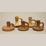 Fig. 59 Chambersticks attributed to James family potters; Yadkin or Davie County, NC; ca. 1850-1930. Earthenware; HOA 4˝ (back left); HOA 3 3/4˝(back right); HOA 3˝ (front left); HOA 3 1/8˝ (front center); HOA 3 1/2˝ (front right). Author’s collection. Photograph by the author. Moravian potters have long been credited with manufacturing chambersticks like these, but no evidence in support of it has been found. Examples possessed by James' family members suggest that James family potters, or other potters nearby, were making them.